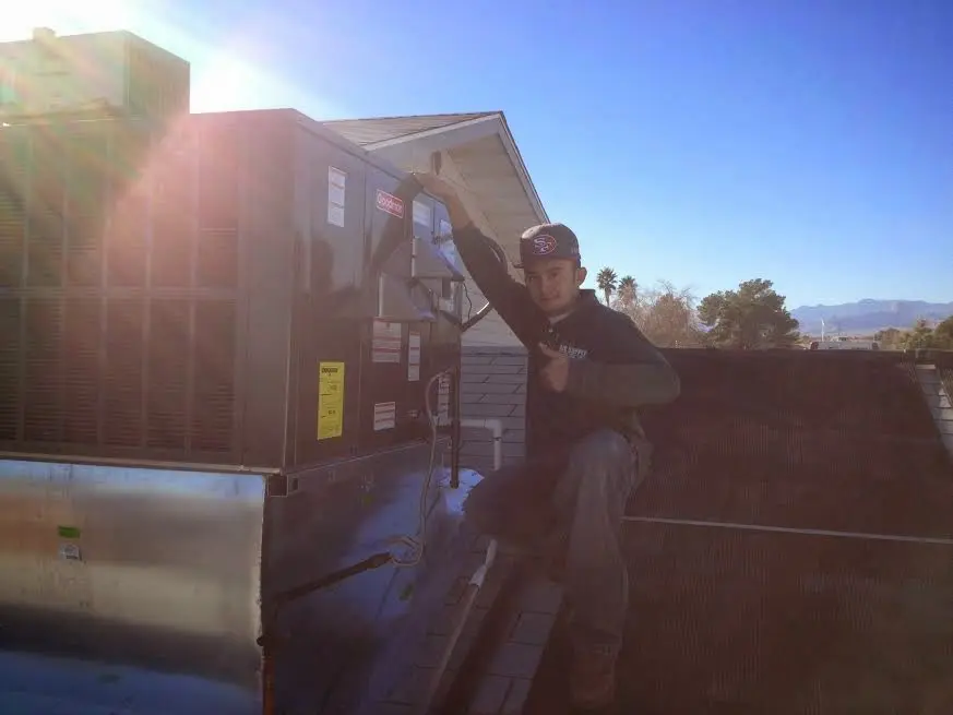 HVAC technician performing HVAC Inspection on a rooftop unit in Conroe